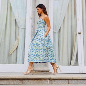 If you are passionate about vintage fashion, we present to you this delicate dress with a modern flair in blue, featuring a beautiful floral design, perfect for your most elegant occasions.