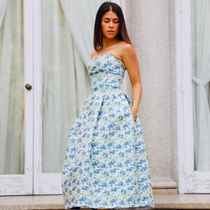 You have an important celebration; if so, we present to you this wonderful knee-length dress in light blue with a floral print and an open back to look elegantly.