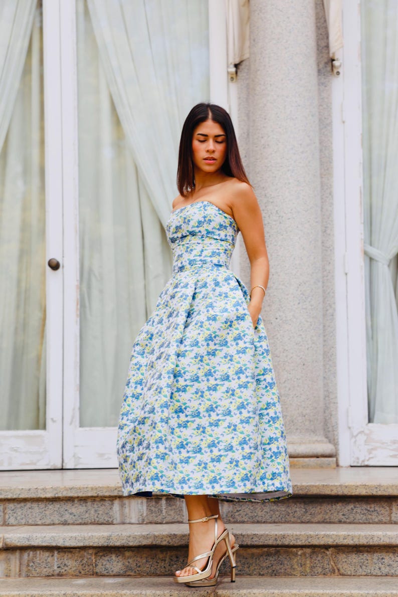 You have an important celebration; if so, we present to you this wonderful knee-length dress in light blue with a floral print and an open back to look elegantly.