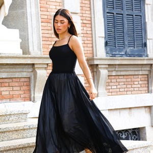 The ultimate guest look. 
Deep black corset top. 
Timeless elegance
Our model pairs the corset with a fluid-cut skirt and slim-heel sandals. The contrast of the deep black against the skin highlights the garment's structure, creating a minimalist yet high-impact guest look.
The structured cut serves as a statement piece, eliminating the need for excessive accessories.