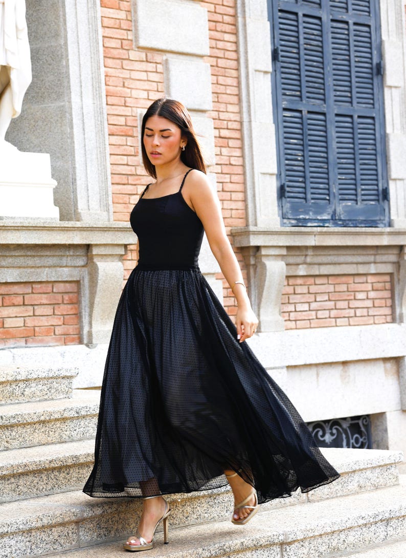 The ultimate guest look. 
Deep black corset top. 
Timeless elegance
Our model pairs the corset with a fluid-cut skirt and slim-heel sandals. The contrast of the deep black against the skin highlights the garment's structure, creating a minimalist yet high-impact guest look.
The structured cut serves as a statement piece, eliminating the need for excessive accessories.