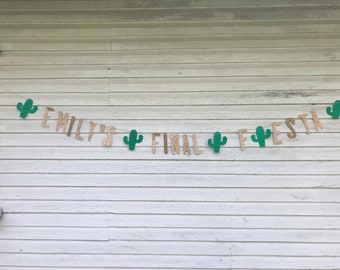 May include: A burlap banner with the text "Emily's Final Fiesta" in gold glitter letters. Green cactus cutouts are strung between the letters.