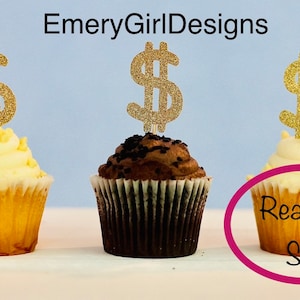 May include: Three cupcakes with gold glitter dollar sign toppers. The cupcakes are ready to ship.