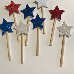 Puede incluir: Surtido de adornos para cupcakes en forma de estrella de purpurina roja, blanca y azul en palitos de madera.