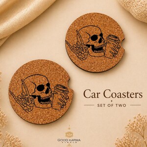 May include: Two round car coasters made of cork, each featuring a black graphic of a skull with a coffee cup and a hand giving the middle finger. The text "Car Coasters" and "SET OF TWO" are also visible.