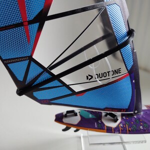 May include: A blue and black windsurf sail with a red stripe and a white logo that says "DUOTONE".