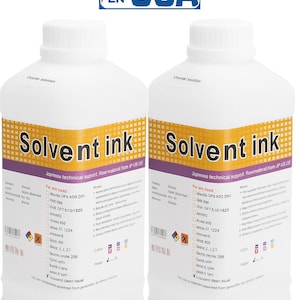 May include: Two white bottles of "Solvent Ink" with yellow and purple labels. The labels include text and a warning symbol. An American flag logo with "EN-USA" is in the top corner.