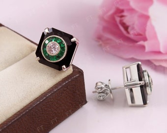 May include: A pair of black and silver earrings with green and white gemstones. The earrings are in a square shape with a round gemstone in the center.