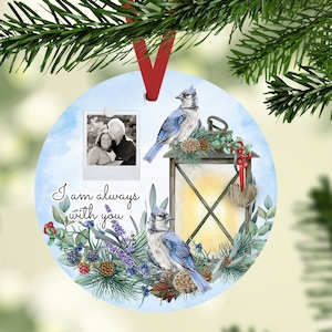 Puede incluir: Un adorno navideño azul y blanco con un marco de fotos, una linterna y dos arrendajos azules. El adorno tiene el texto "Siempre estoy contigo" y un corazón.
