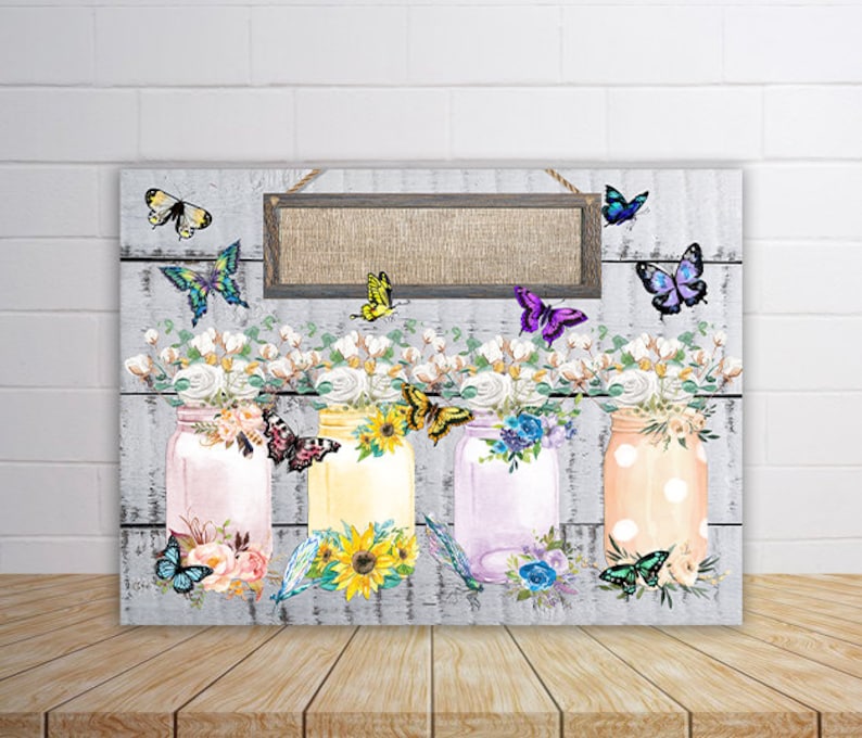May include: Three mason jars with floral arrangements and butterflies, painted in a watercolor style. The jars are decorated with polka dots, stripes, and flowers. A wooden sign with a burlap background hangs above the jars.