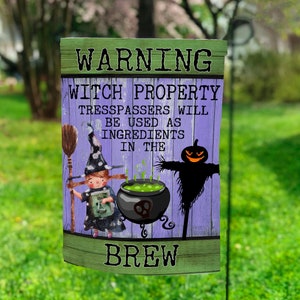 Könnte beinhalten: Eine violette und grüne Halloween-Gartenflagge mit einer Hexe, einem Kessel und einem Vogelscheuche. Der Text auf der Flagge lautet "Warning Witch Property Trespassers Will Be Used As Ingredients In The Brew".