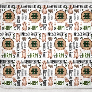 May include: White baby blanket with a repeating pattern of brown bears, green trees, and the text "Harrison Robert" and "HRM".