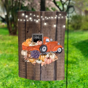 Può includere: Un camioncino vintage rosso con un cartello in ardesia che dice "Pumpkins &" è pieno di zucche e zucche. Il camioncino è su uno sfondo di legno con luci a catena.