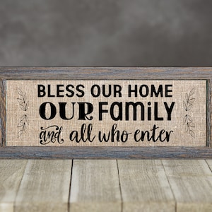 Puede incluir: Un letrero de madera rústico con un fondo de arpillera y el texto "Bless our home our family and all who enter".