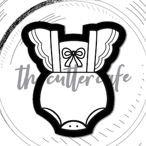 May include: A black and white cookie cutter shaped like a summer romper, presented on a white plate against a dark grey backdrop. The text "the cutter cafe" and "summer romper" are visible.