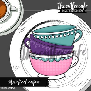 May include: A stack of three teacups on a white plate. The top cup is teal blue with white dots, the middle cup is purple with white swirls, and the bottom cup is pink with white dots and a teal blue trim.