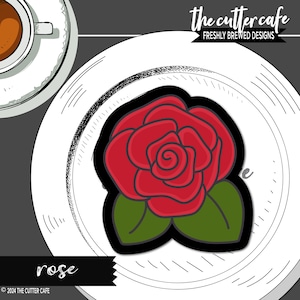 May include: A red rose with green leaves on a white plate. The text "rose" is below the plate and "the cutter cafe" is above the plate.