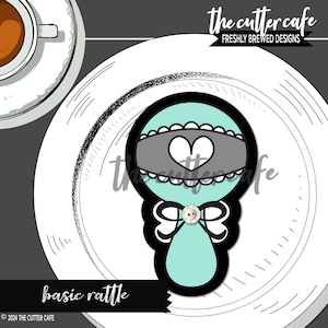 May include: A teal blue baby rattle cookie cutter with a white bow, a white heart, and a grey band. The text "basic rattle" is below the cutter.
