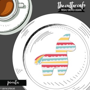 Peut inclure: Une pinata colorée en forme d'âne avec des rayures rouges, jaunes, bleues et blanches. La pinata est sur une assiette blanche avec une bordure dessinée en noir et blanc. Le texte "the cutter cafe" et "freshly brewed designs" est en haut de l'image. Le texte "pinata" est en bas de l'image.