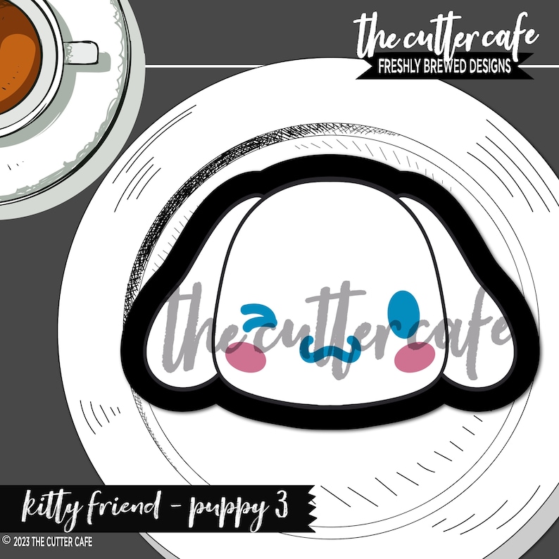 May include: A black and white cookie cutter shaped like a puppy's head with blue and pink details. The cutter is on a white plate with the text "the cutter cafe" in black and white.