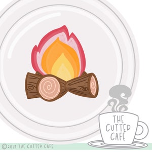 Puede incluir: Un plato blanco con una ilustración de dibujos animados de una fogata con llamas naranjas y rosadas y troncos marrones. El texto "THE CUTTER CAFE" está en una taza gris con vapor saliendo de ella.