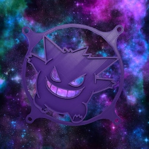 Könnte beinhalten: Ein lila 3D-gedrucktes Gengar-Charakterdesign mit einem kreisförmigen Rahmen und vier Befestigungspunkten. Gengars Gesicht zeigt ein schelmisches Grinsen, mit einem durch die Öffnungen sichtbaren Galaxiemuster. Der Hintergrund ist eine farbenfrohe Galaxie.