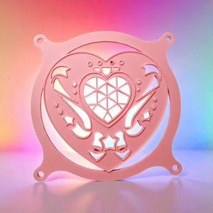 May include: A pink, heart-shaped decorative light fixture with a geometric design in the centre. The fixture has a decorative border with star and bow accents. The light is illuminated with a soft, white glow.