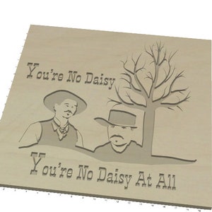 Peut inclure: Plaque en bois clair avec l'inscription grav&eacute;e "You're No Daisy At All". Le design pr&eacute;sente deux hommes portant des chapeaux et un arbre nu. L'&oelig;uvre est un design sur le th&egrave;me de l'Ouest.
