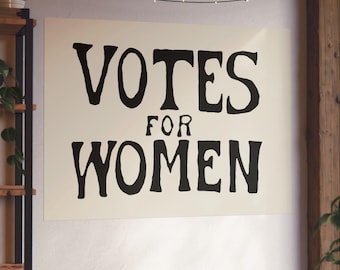 May include: A rectangular wall poster featuring a cream-colored background with the bold, black, hand-lettered text VOTES FOR WOMEN centered in the middle. The lettering has a distinct, slightly irregular, and organic serif typeface style.