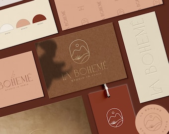 Peut inclure: Une maquette de marque pour une entreprise appelée "La Bohème Studio à Paris". Le logo représente une chaîne de montagnes stylisée avec un soleil et une seule plante. Le logo est imprimé sur différentes surfaces, notamment une carte de visite, une étiquette et une enveloppe.