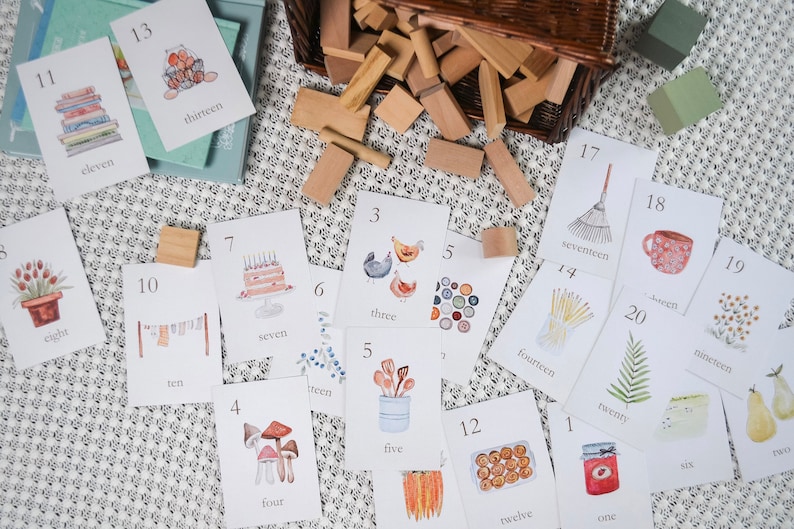Puede incluir: Un conjunto de 20 tarjetas ilustradas que presentan los n&uacute;meros del uno al veinte con im&aacute;genes y palabras correspondientes. Las tarjetas son blancas con texto negro e ilustraciones coloridas.
