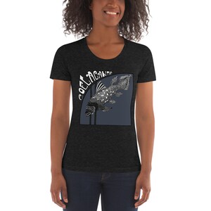May include: A dark heather grey women's t-shirt with a scoop neck. The shirt features a graphic of a coelacanth fish with the word "COELACANTH" written in a stylized font.