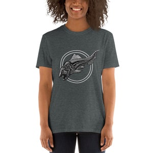 May include: A dark heather grey t-shirt featuring a black and white illustration of a prehistoric fish within a circle.