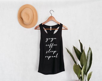 Può includere: Canotta nera con la scritta "yoga coffee sleep repeat" in lettere bianche.