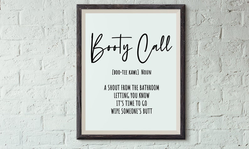 May include: Framed wall art with the words "Booty Call" in a black script font. The definition is below, with the pronunciation, and the phrase "A shout from the bathroom letting you know it's time to go wipe someone's butt."