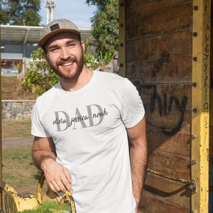 May include: A white t-shirt with the word "DAD" printed in gray with the names "olivia, jessica, noah" printed underneath.