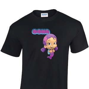 May include: Black t-shirt with a purple cartoon mermaid character and the word "Oona" in purple letters.