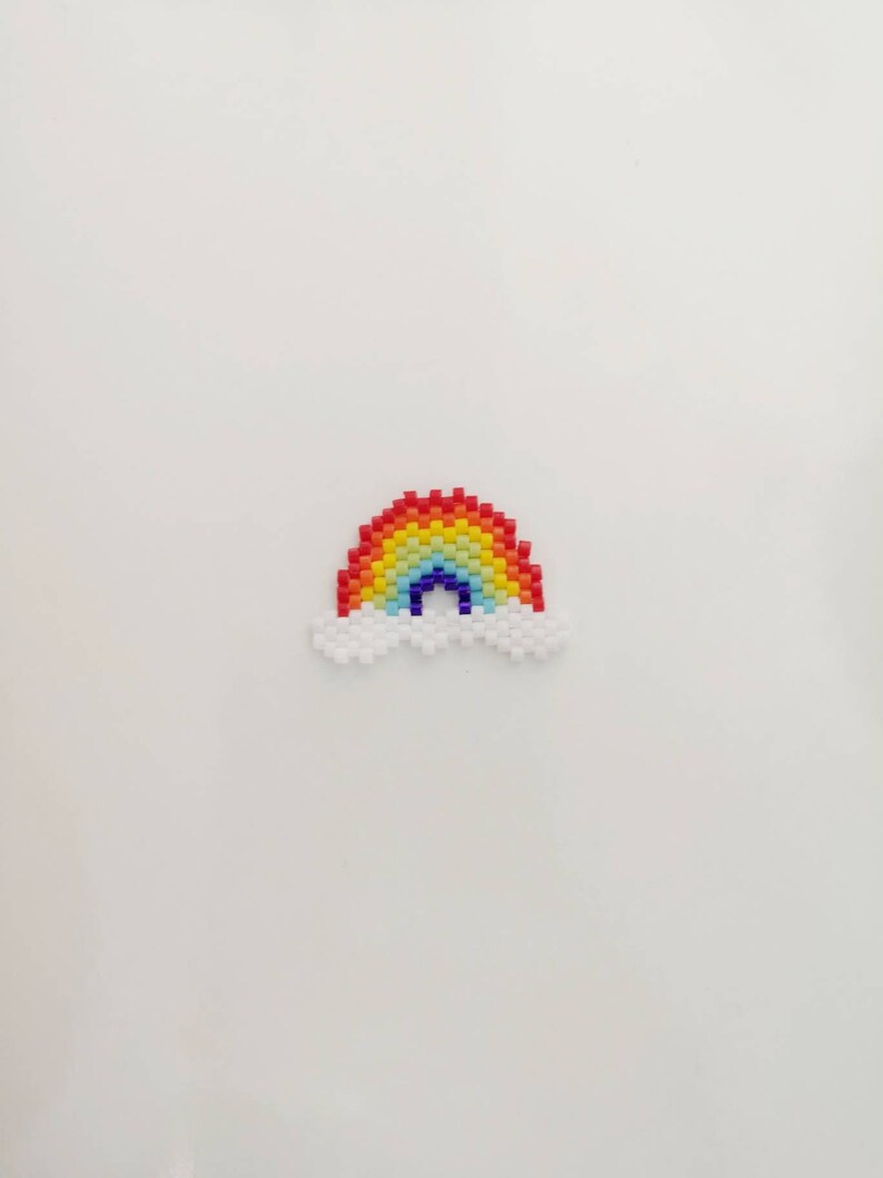 May include: A rainbow made of colorful beads with a white cloud on each side.