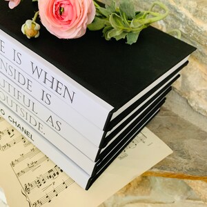 May include: A stack of black and white hardback books with the text "When life is inside is as beautiful outside." on the top book.