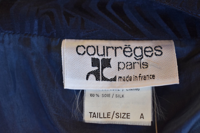May include: A white tag with black text that reads "courr&egrave;ges paris made in france" and "100% SOIE/SILK LINING TAILLE/SIZE A".