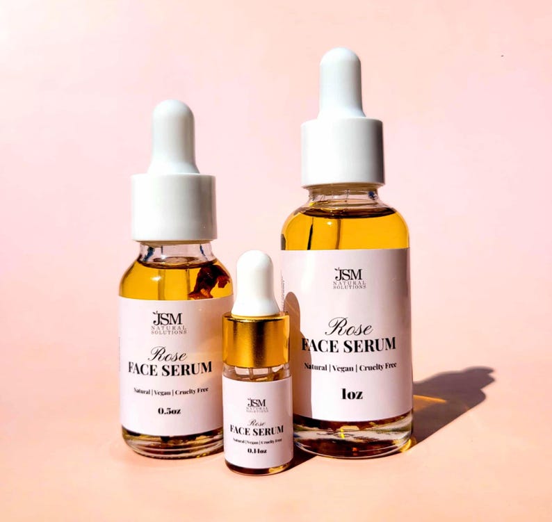 May include: Three glass bottles of Rose Face Serum with white droppers and labels. The bottles are filled with a golden liquid. The labels read "Rose Face Serum" and "Natural | Vegan | Cruelty Free". The sizes are 0.1 oz, 0.5 oz, and 1 oz.
