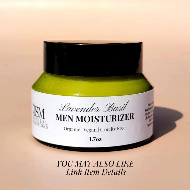 May include: A jar of Lavender Basil Men Moisturizer. The jar has a black lid and a white label with text that reads "Organic | Vegan | Cruelty Free" and "1.7oz". The moisturizer inside is light green.