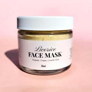 K&ouml;nnte beinhalten: Ein klares Glas mit wei&szlig;em Deckel, gef&uuml;llt mit einer gelben Gesichtsmaske. Das Etikett lautet "Licorice FACE MASK" mit "Organic | Vegan | Cruelty Free" darunter. Das Glas enth&auml;lt 57g Produkt.