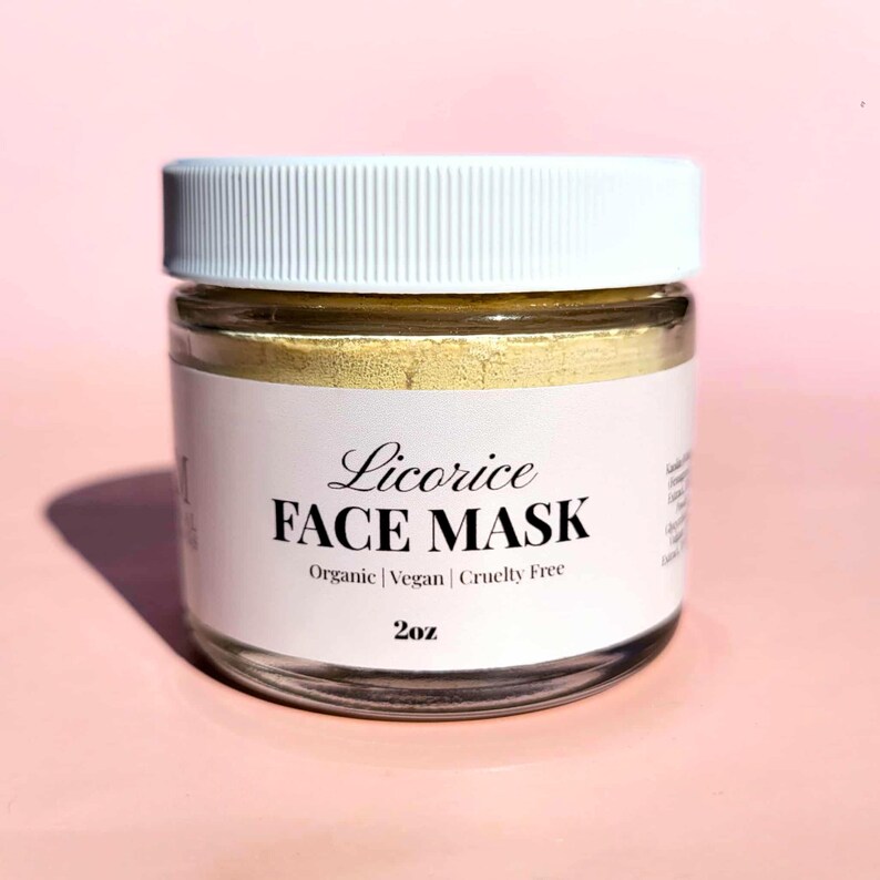 K&ouml;nnte beinhalten: Ein klares Glas mit wei&szlig;em Deckel, gef&uuml;llt mit einer gelben Gesichtsmaske. Das Etikett lautet "Licorice FACE MASK" mit "Organic | Vegan | Cruelty Free" darunter. Das Glas enth&auml;lt 57g Produkt.