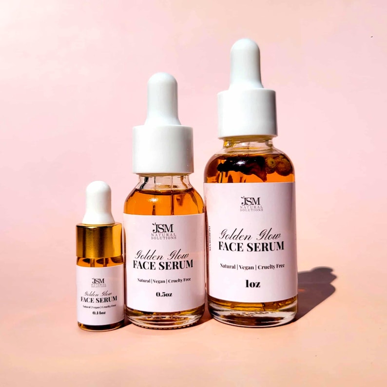 May include: Three glass bottles of Golden Glow Face Serum with white droppers. The bottles are labeled with the brand name and product details. The serum is amber-colored. The sizes are 0.1 fl oz, 0.5 fl oz, and 1 fl oz.