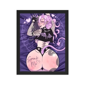 May include: Framed art print featuring a stylized illustration of a character with pink hair, horns, and a tail. The character is wearing a black top with the text "BAD GIRL" and has the words "Spank Me" on their backside. The background is purple.