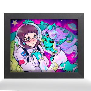 May include: Framed artwork featuring a colorful illustration of two figures. One figure is in a NASA spacesuit, the other is an alien with teal skin and purple hair. The background is a vibrant mix of pink, purple, and green, with stars and a UFO.
