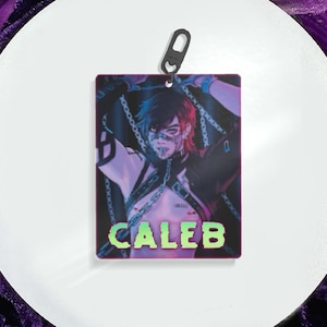 Op de afbeelding: Een rechthoekige acryl bedel met een digitale illustratie van een persoon met kettingen en de naam "CALEB" in groen. Het kunstwerk heeft een donkere, futuristische esthetiek met een kleurenpalet van zwart, wit en paars.