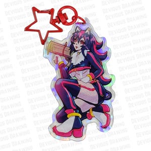 Op de afbeelding: Een heldere acryl bedel met een gestileerd anime-personage in een dynamische pose. Het personage draagt een zwart en roze outfit en houdt een bruin voorwerp vast. De bedel heeft een rode stervormige sluiting en een ronde sluiting.
