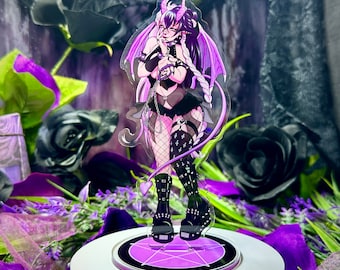 May include: A clear acrylic figure of a character with purple and black hair, horns, and wings. The character is wearing a black outfit with fishnet stockings and platform boots. The figure is on a circular stand with a purple pentagram design.